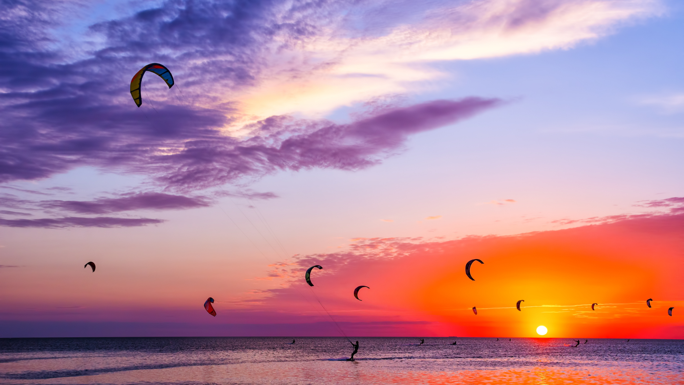 Kiters in den Niederlanden bei rotem Sonnenuntergang.